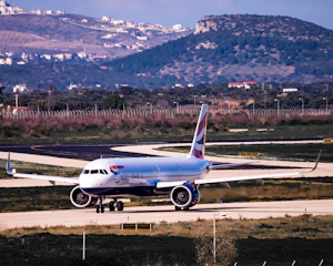 white and blue airplane on airport during daytime