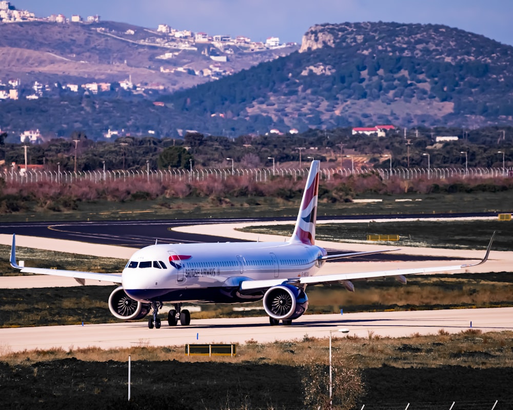 white and blue airplane on airport during daytime