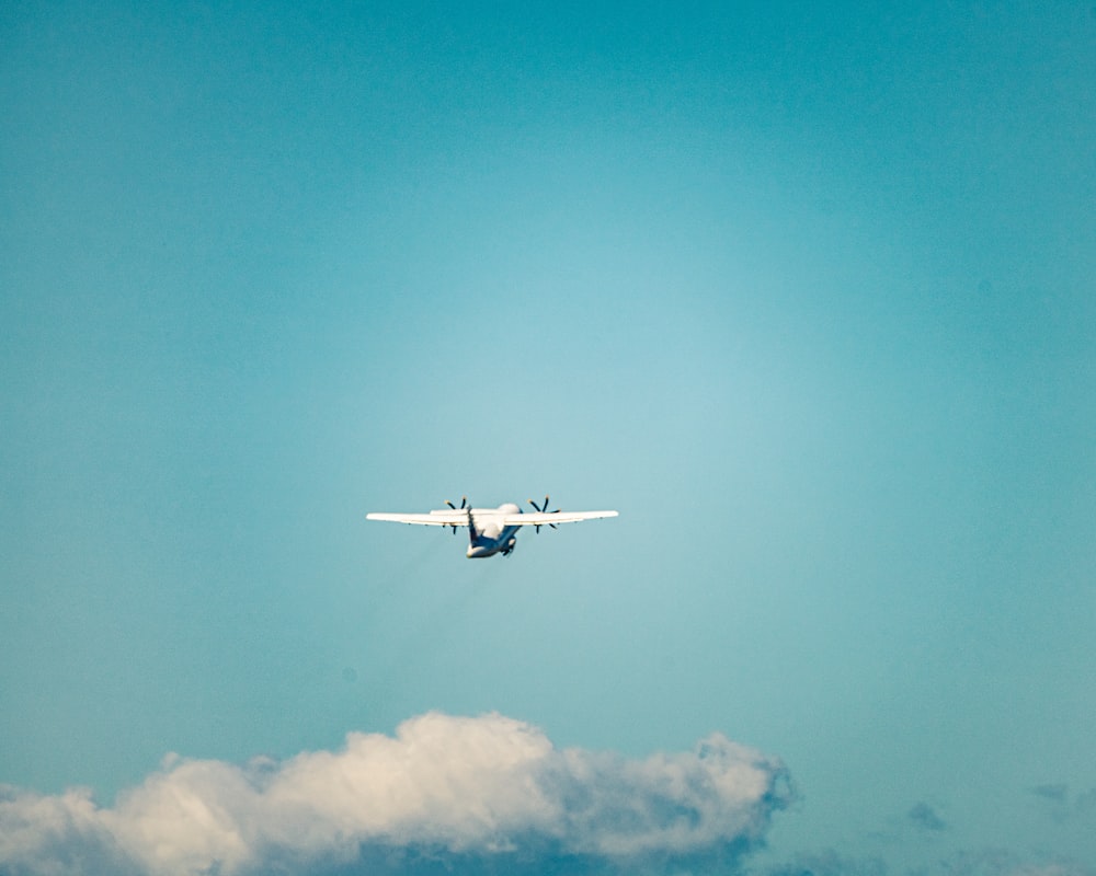 white and black airplane in mid air during daytime