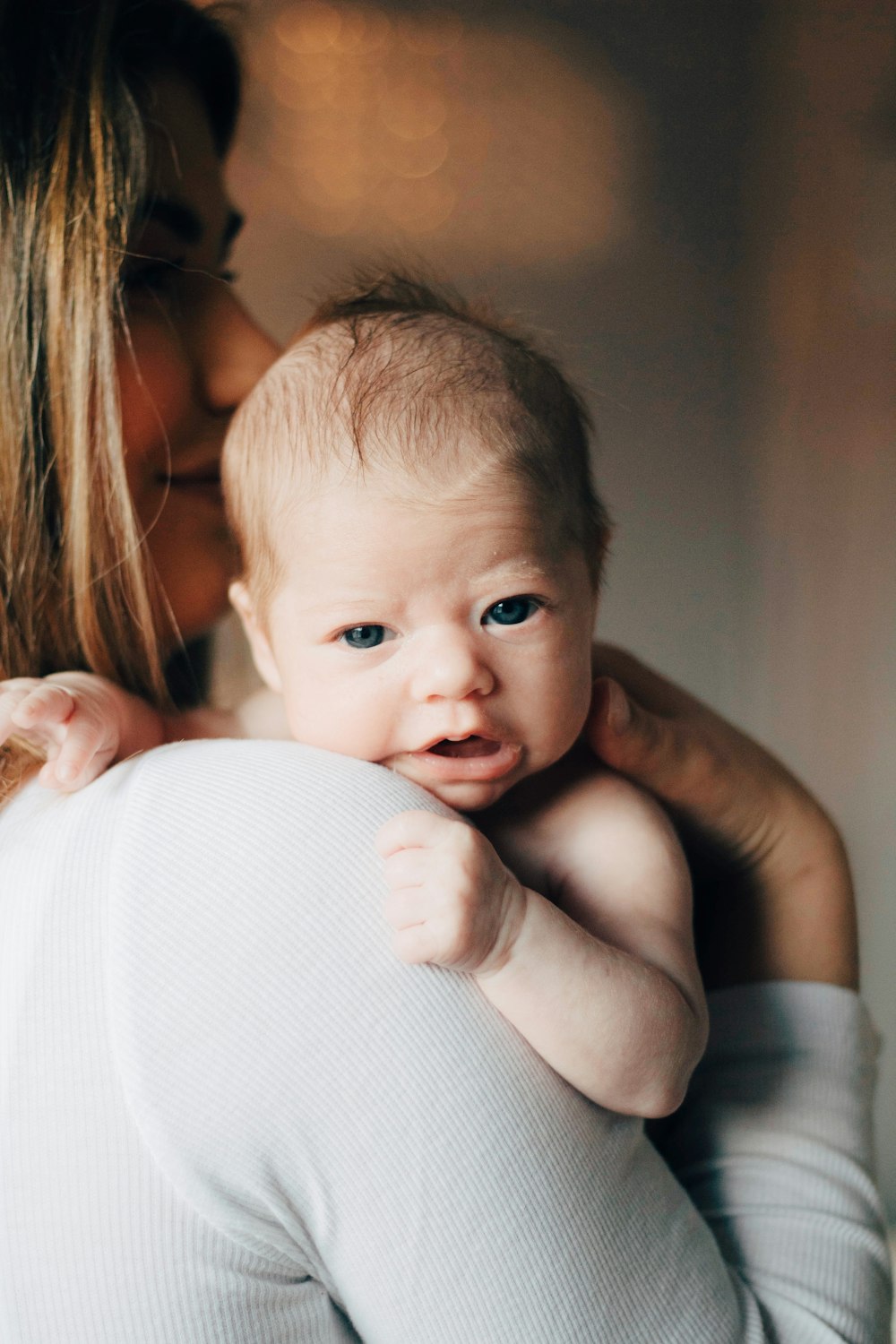 Frau im weißen Hemd trägt Baby