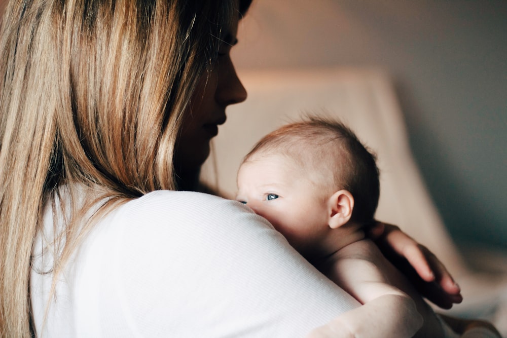 Frau im weißen Hemd trägt Baby