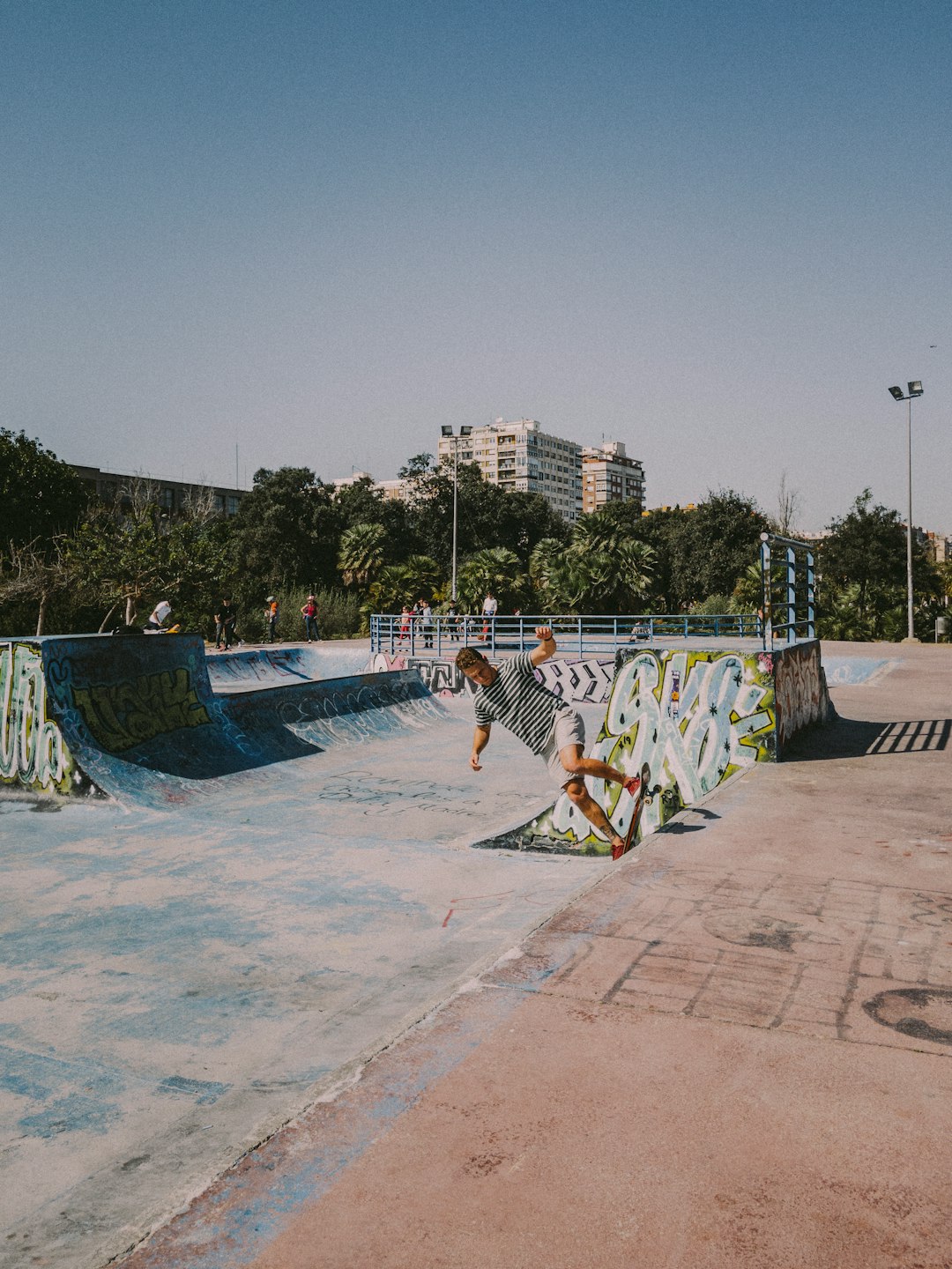 people sitting on concrete bench near swimming pool during daytime