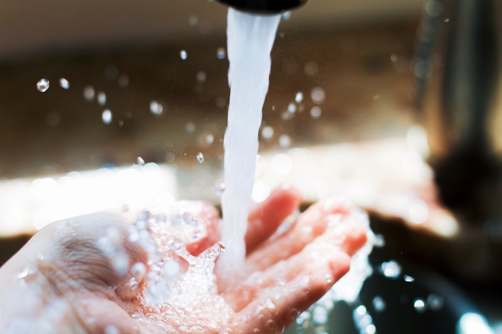 person holding water drop on water