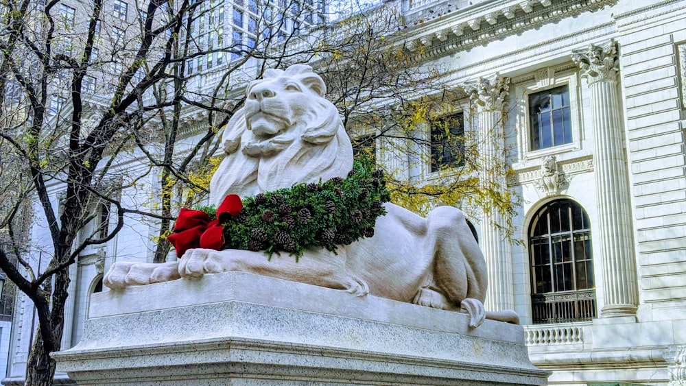 white and red roses on white concrete statue