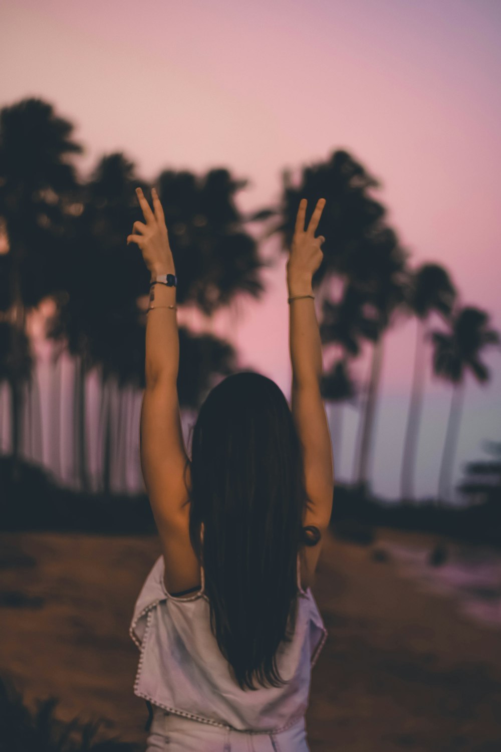 woman in white shirt raising her hands