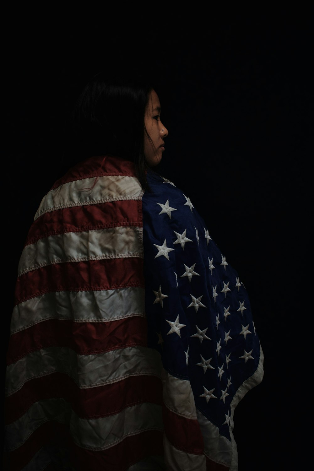 a woman wrapped in an american flag blanket