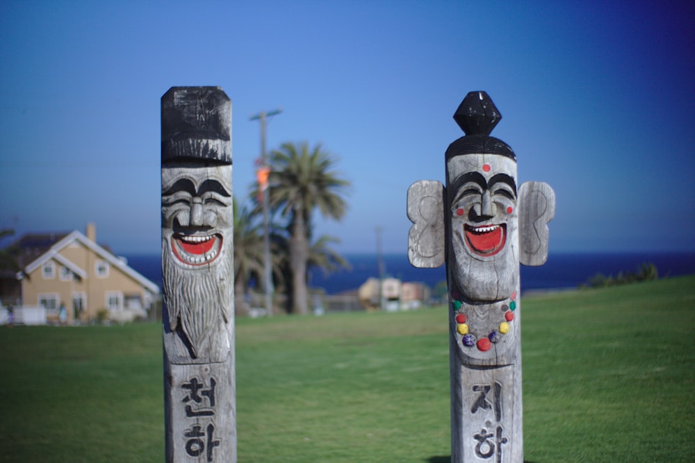 brown wooden tribal mask on green grass field during daytime