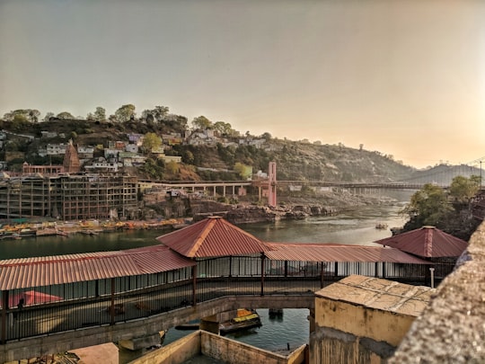 brown and white houses near body of water during daytime in Omkareshwar India