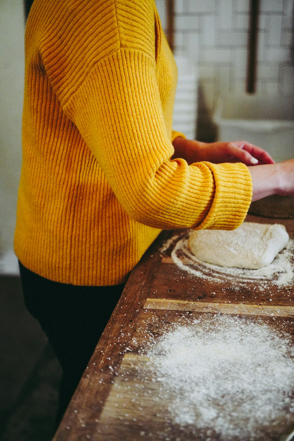 person in yellow sweater holding white powder