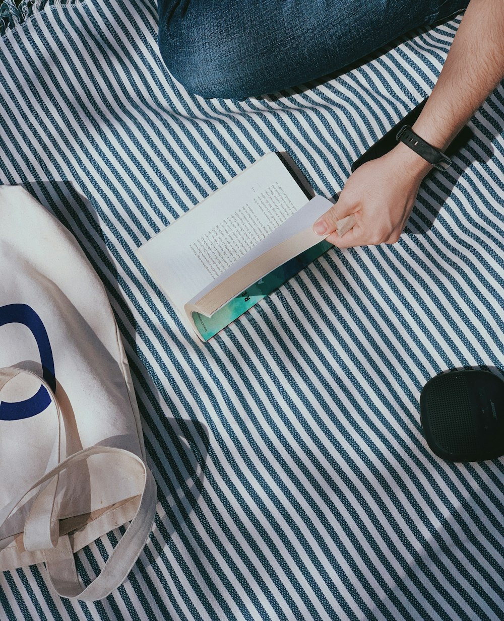 a person is reading a book on a blanket