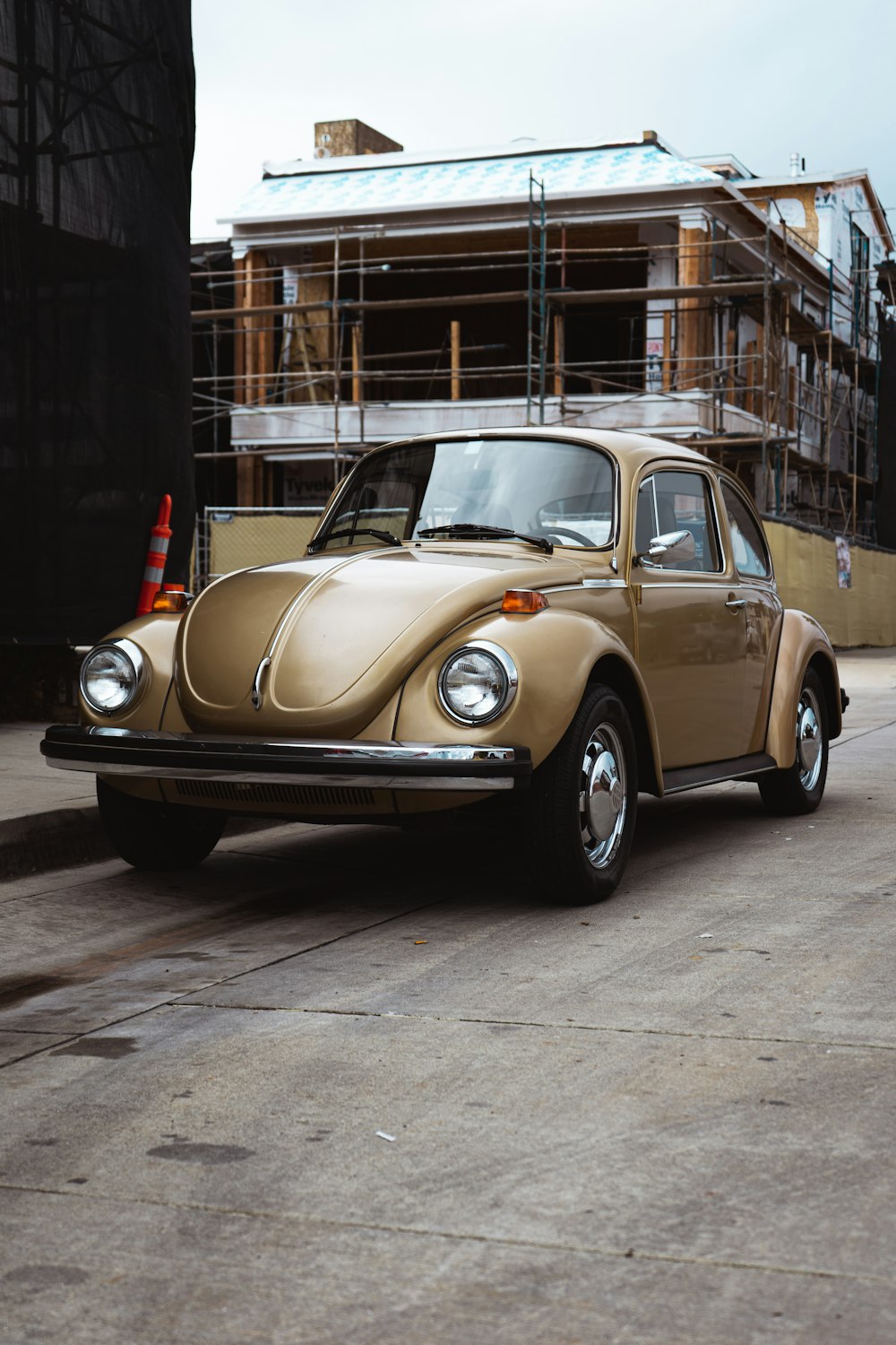 brown and white volkswagen beetle parked on sidewalk during daytime