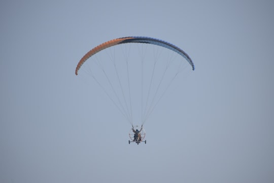 person in black jacket and blue jeans riding on orange parachute in Manesar India