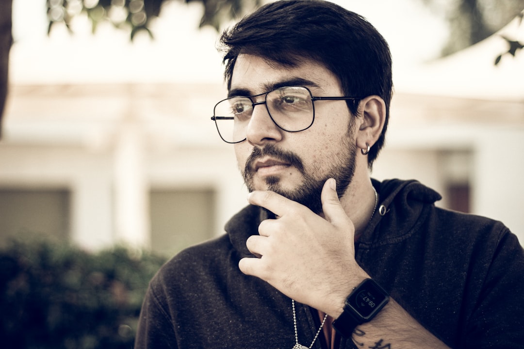 man in black framed eyeglasses and blue sweater