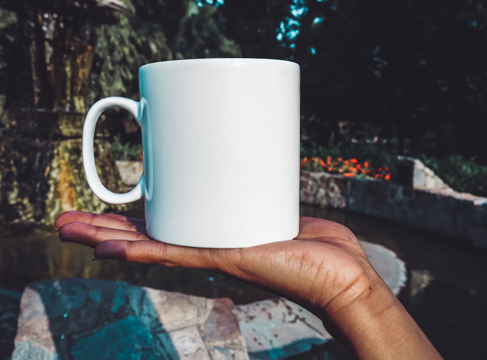 person holding white ceramic mug