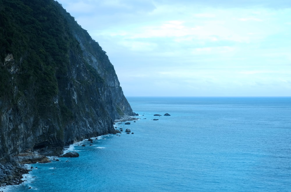 body of water near mountain during daytime