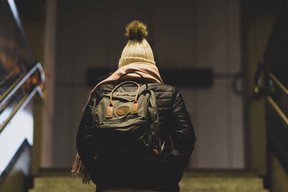 person in black leather jacket wearing brown and black backpack