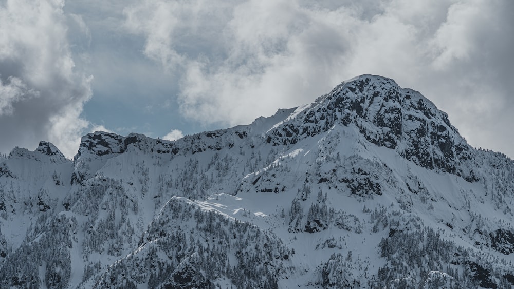 Montagna coperta di neve sotto il cielo nuvoloso durante il giorno