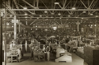 A busy factory floor with skilled workers assembling products under bright lights.