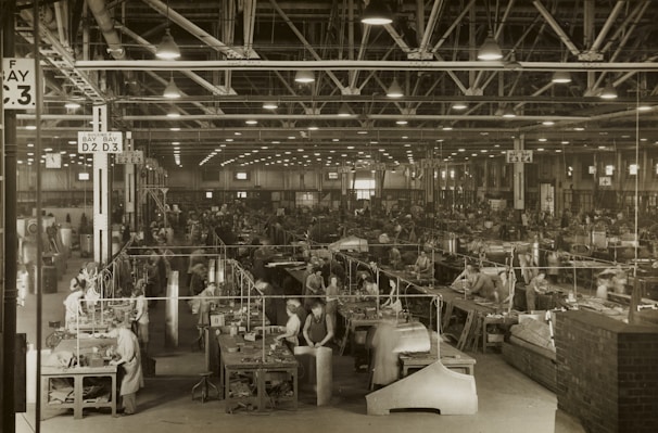 A busy factory floor with skilled workers assembling products under bright lights.