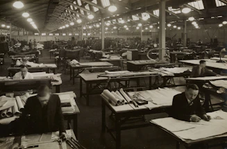 Engineers collaborating over blueprints inside a modern industrial plant.