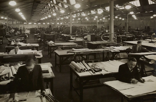 Engineers collaborating over blueprints inside a modern industrial plant.