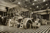 Technicians performing maintenance on heavy machinery inside an industrial plant
