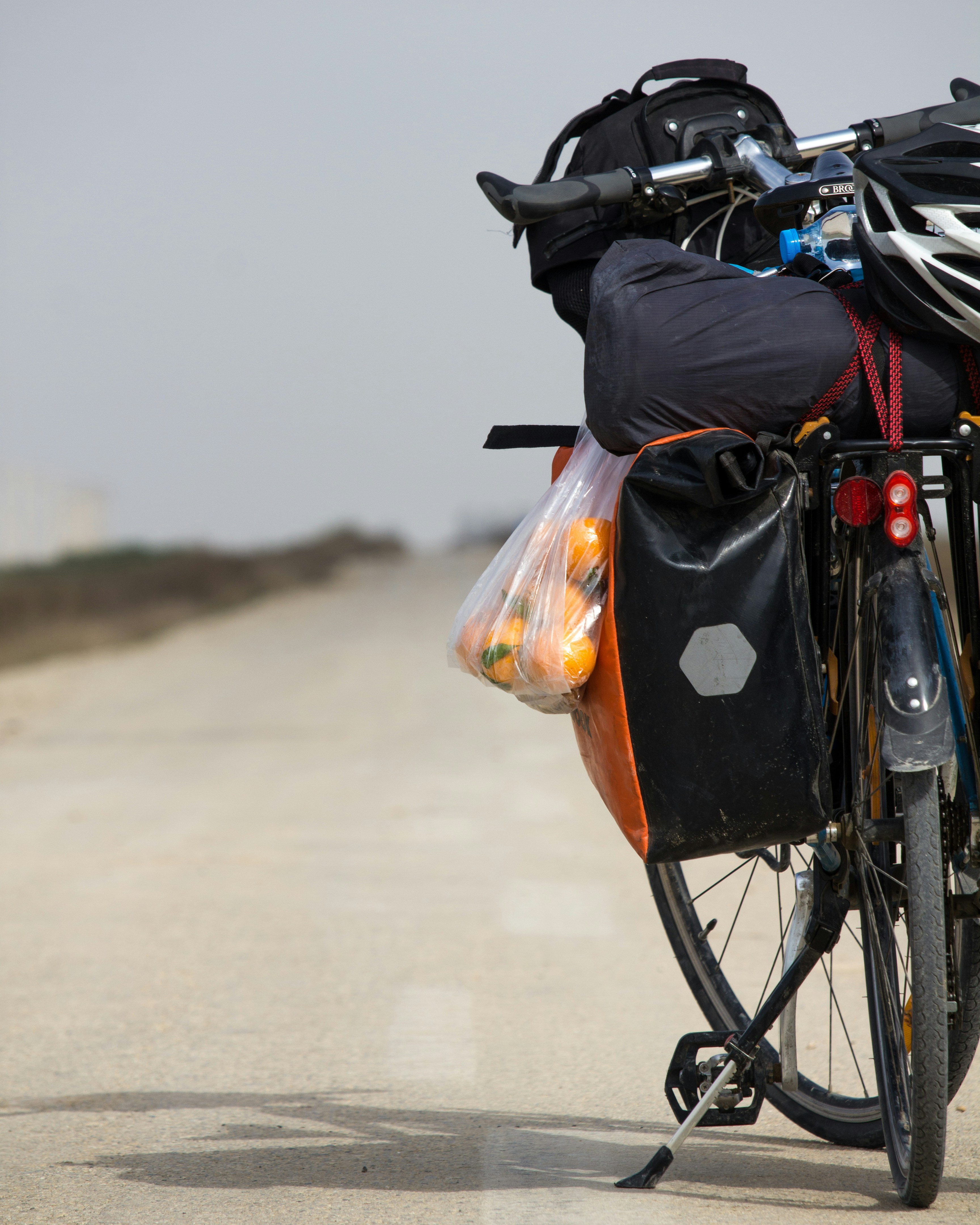 black bicycle with black and orange bag on the back