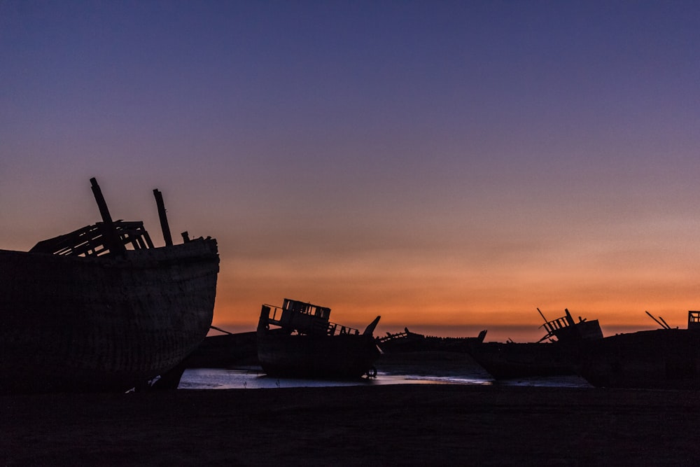 silhouette of ship on sea during sunset