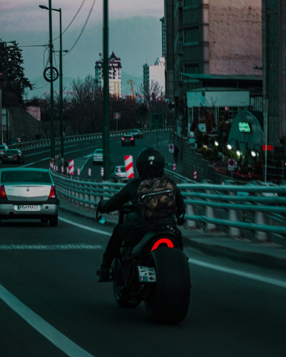 man in black helmet riding on black motorcycle on road during daytime