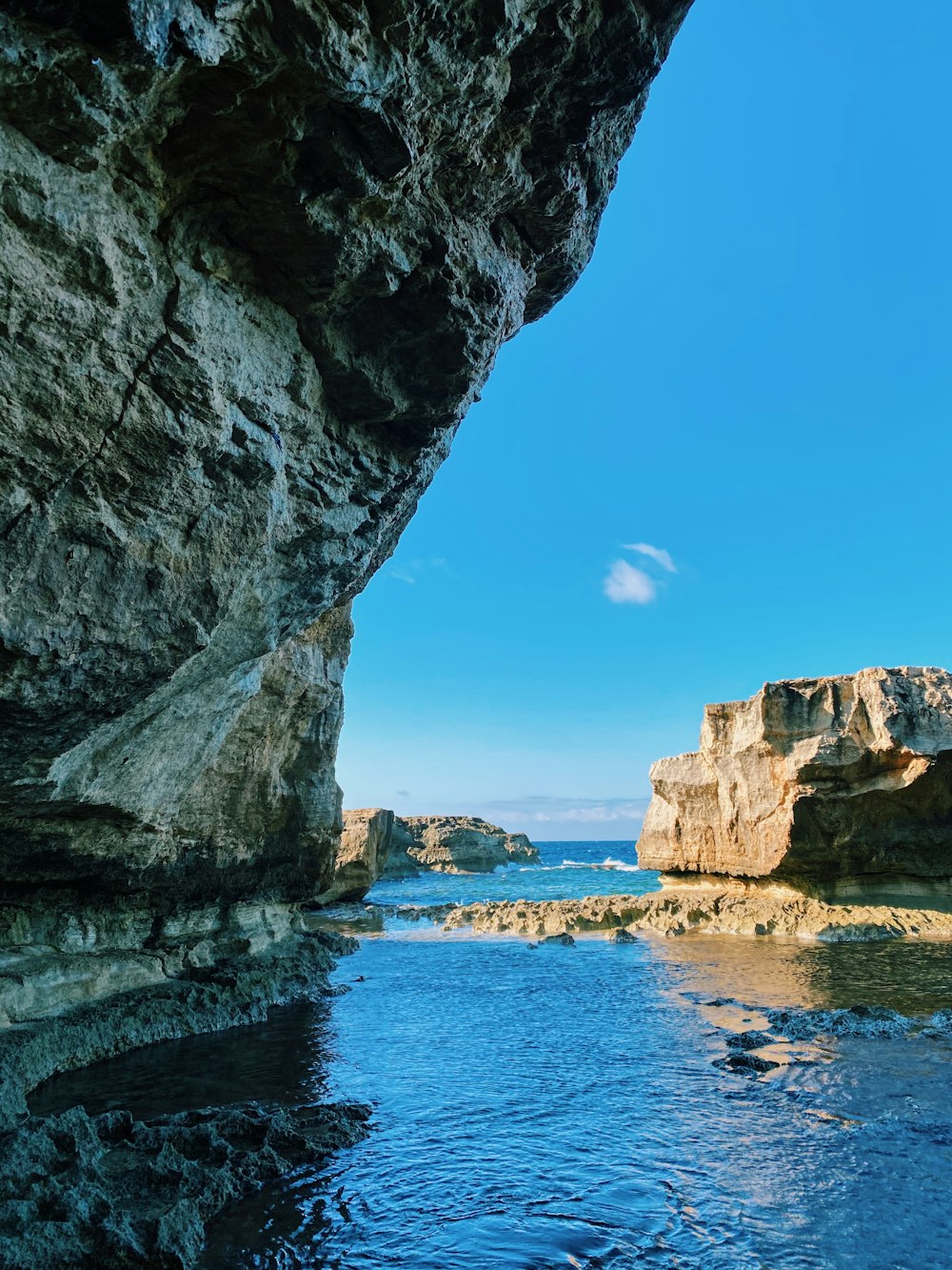 brown rock formation near body of water during daytime