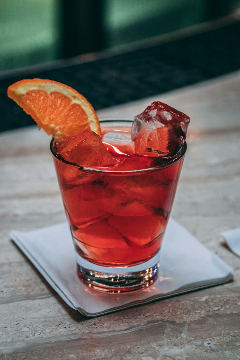 clear drinking glass with red liquid and sliced orange fruit