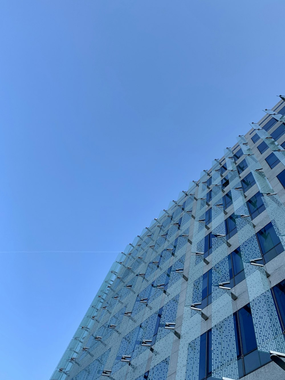 blue and white glass walled high rise building