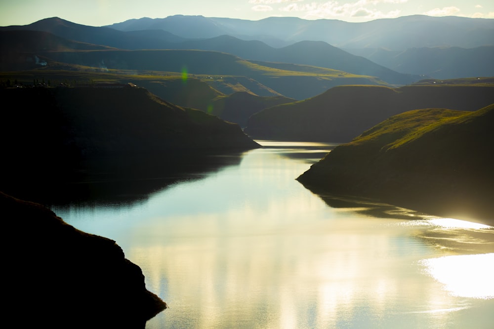 green mountains beside lake during daytime