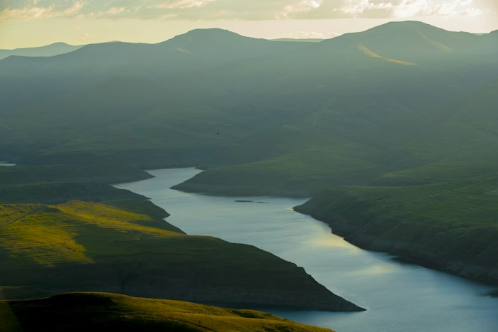 Green mountains beside a lake in Lesotho, home of a growing free Lesotho dating app community