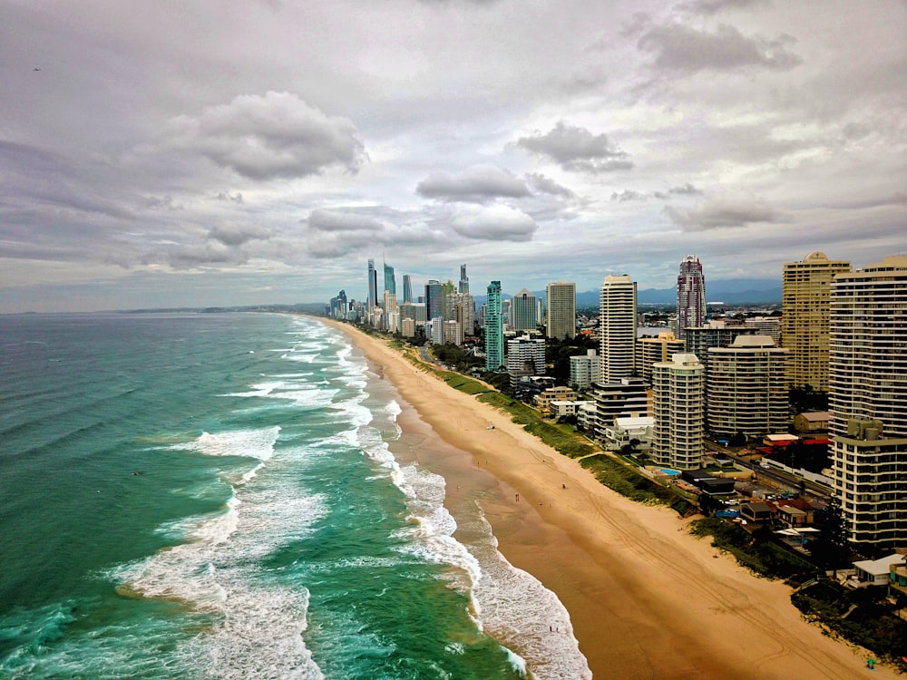 high rise buildings near sea under white clouds during daytime