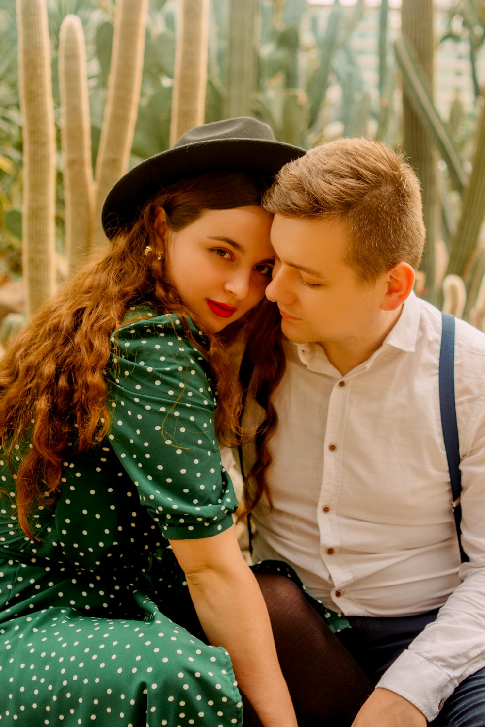 man in white dress shirt beside girl in green and black polka dot dress