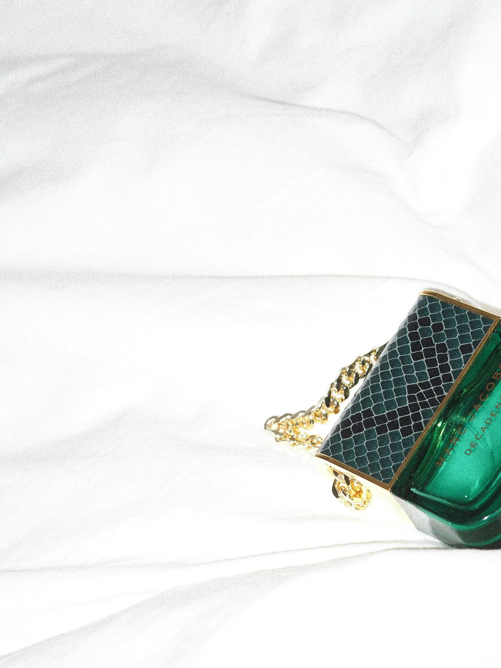 gold and green gemstone ring on white textile
