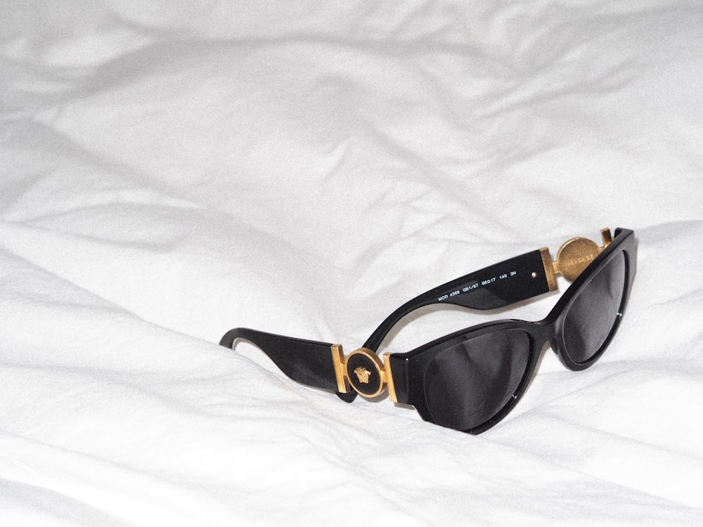 Un par de gafas de sol encima de una cama