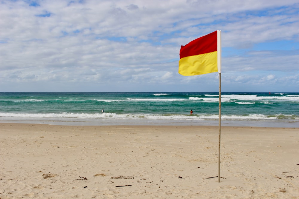 red yellow and green flag on beach shore during daytime