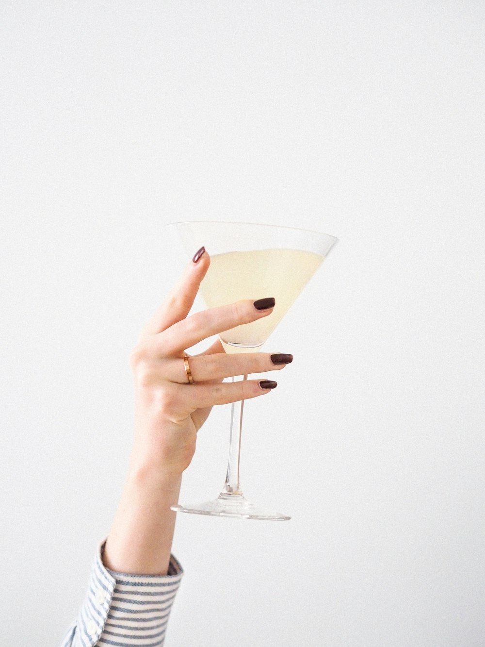 Persona sosteniendo una copa de martini transparente