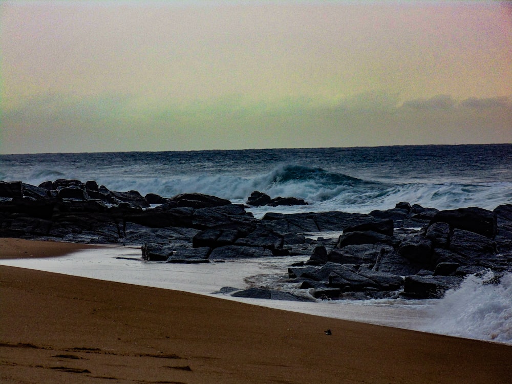 sea waves crashing on shore during daytime