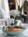 A bowl of creamy tahini drizzled over a vibrant salad, styled on a minimalist wooden table.