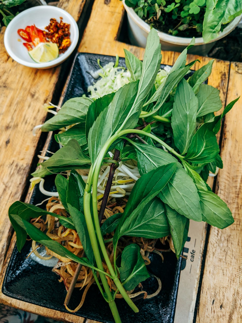 hojas verdes sobre una mesa de madera marrón