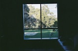 A cozy hotel room with large windows overlooking a lush green landscape.