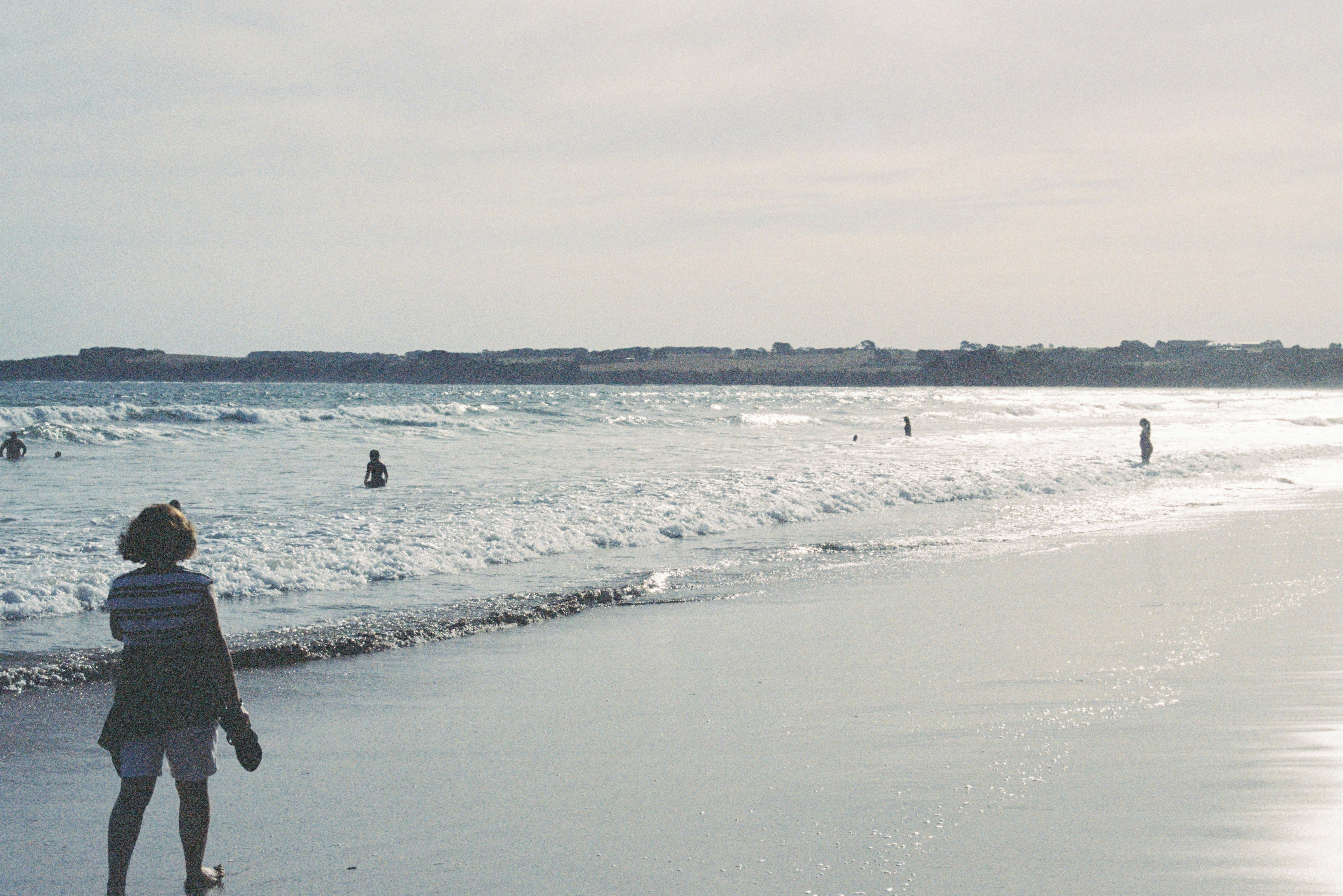 woman walking down the shore at the beach