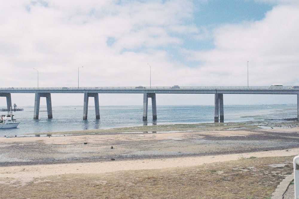 gray concrete bridge on sea under white clouds during daytime