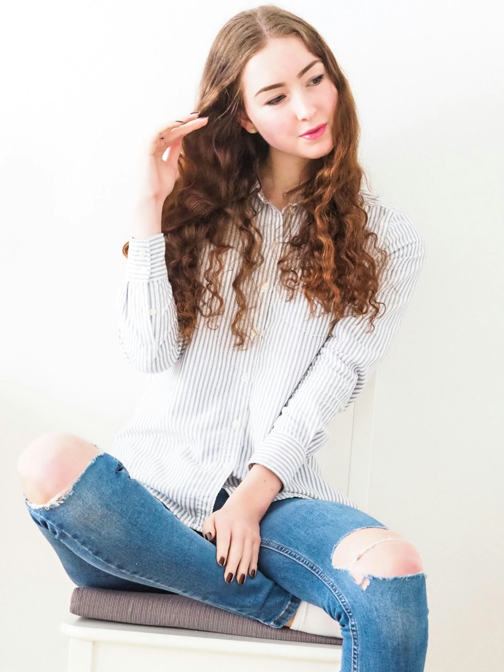 Femme en pull en maille blanche et jean en denim bleu