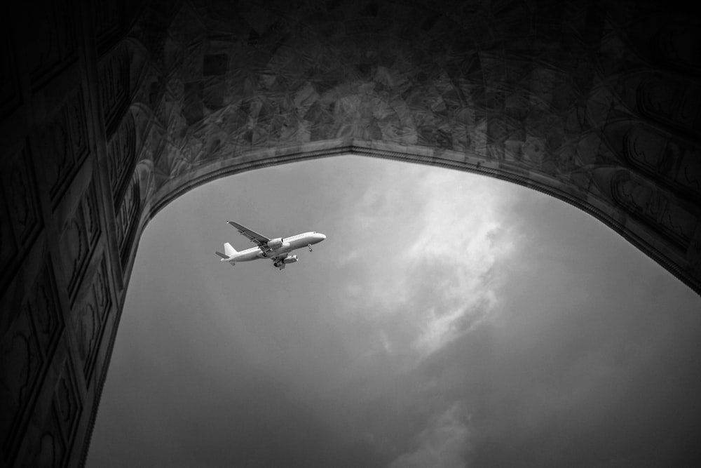 grayscale photo of airplane in mid air