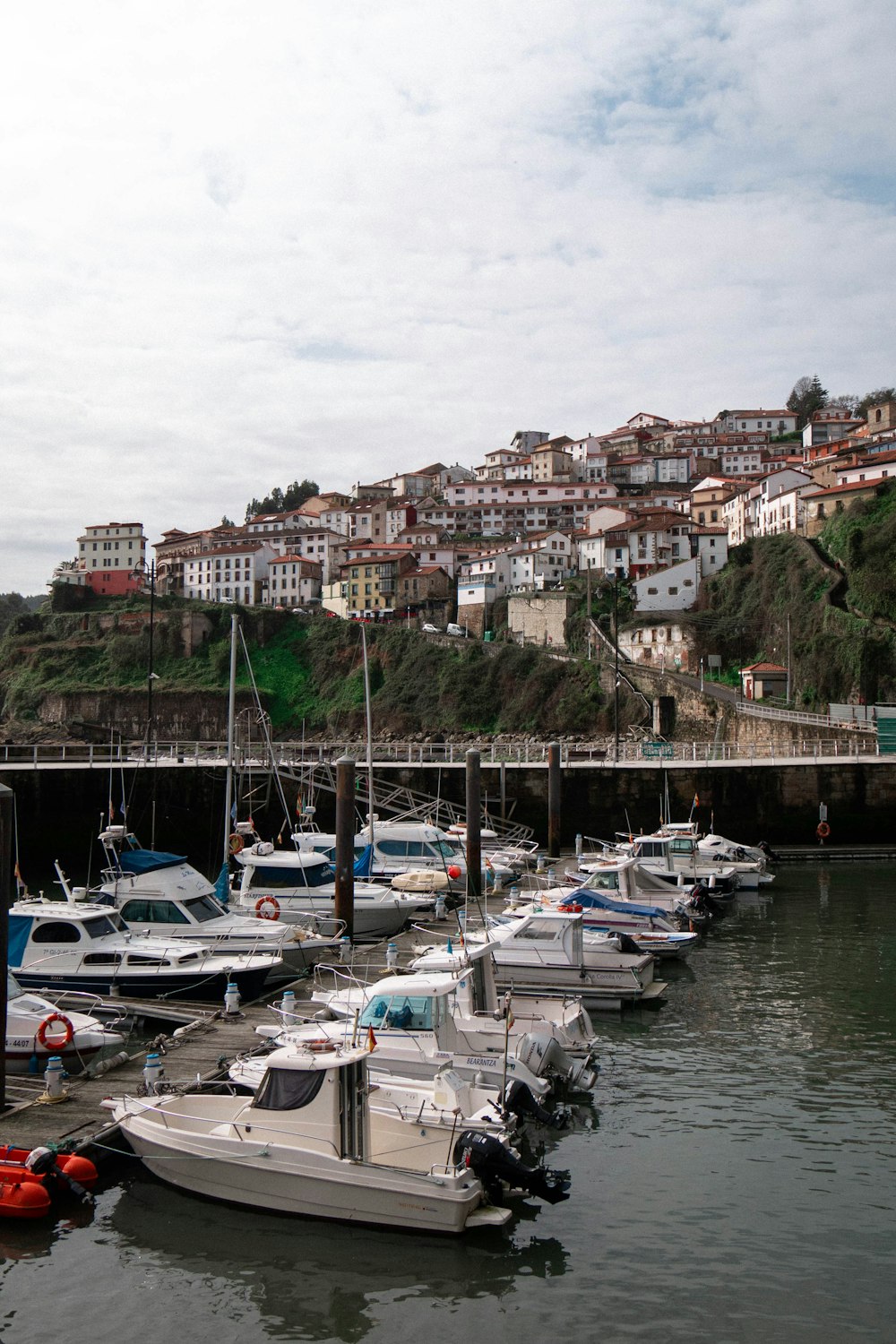 white and blue boats on dock near city buildings during daytime