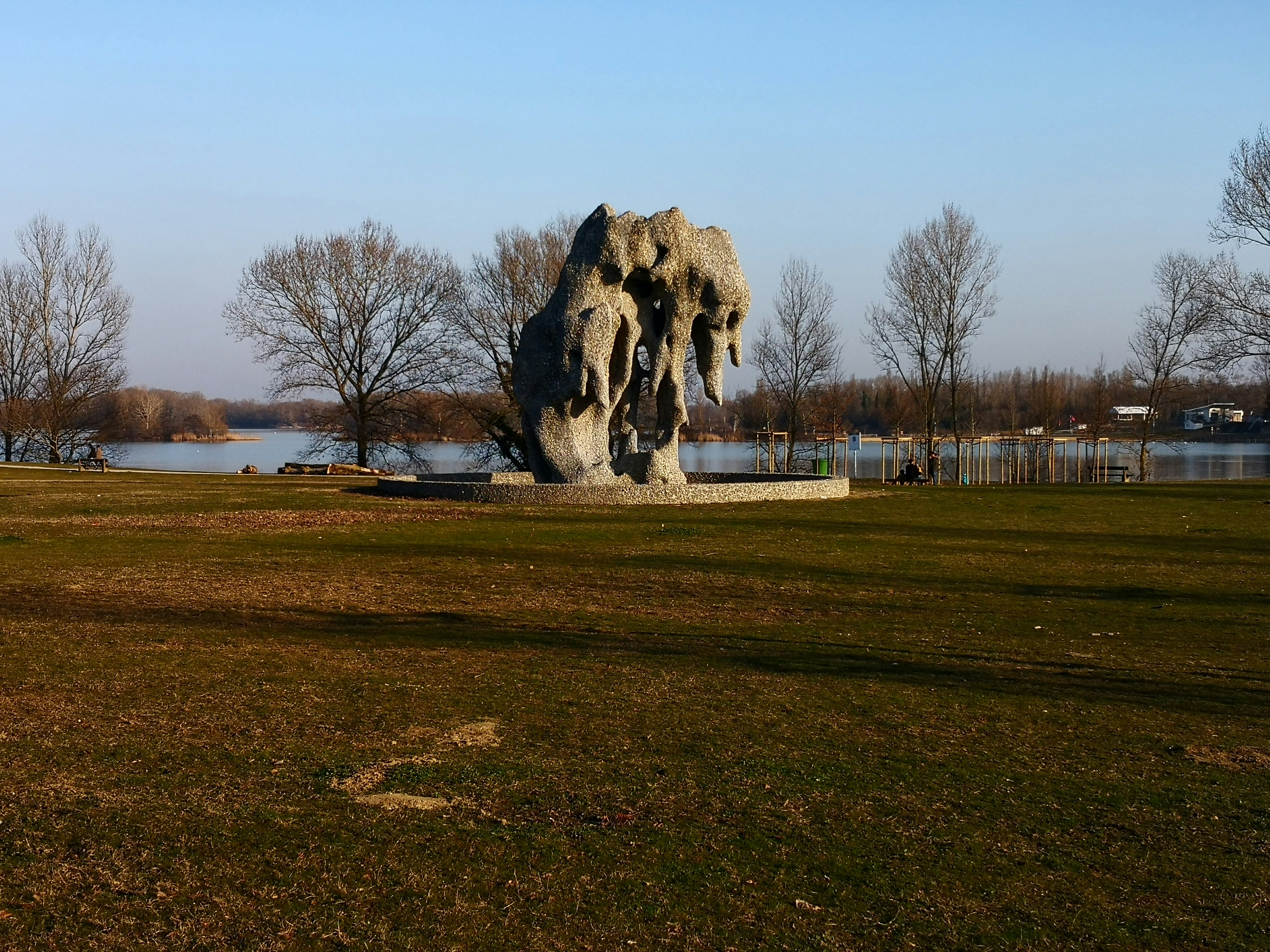 brown and white horse statue on green grass field during daytime
